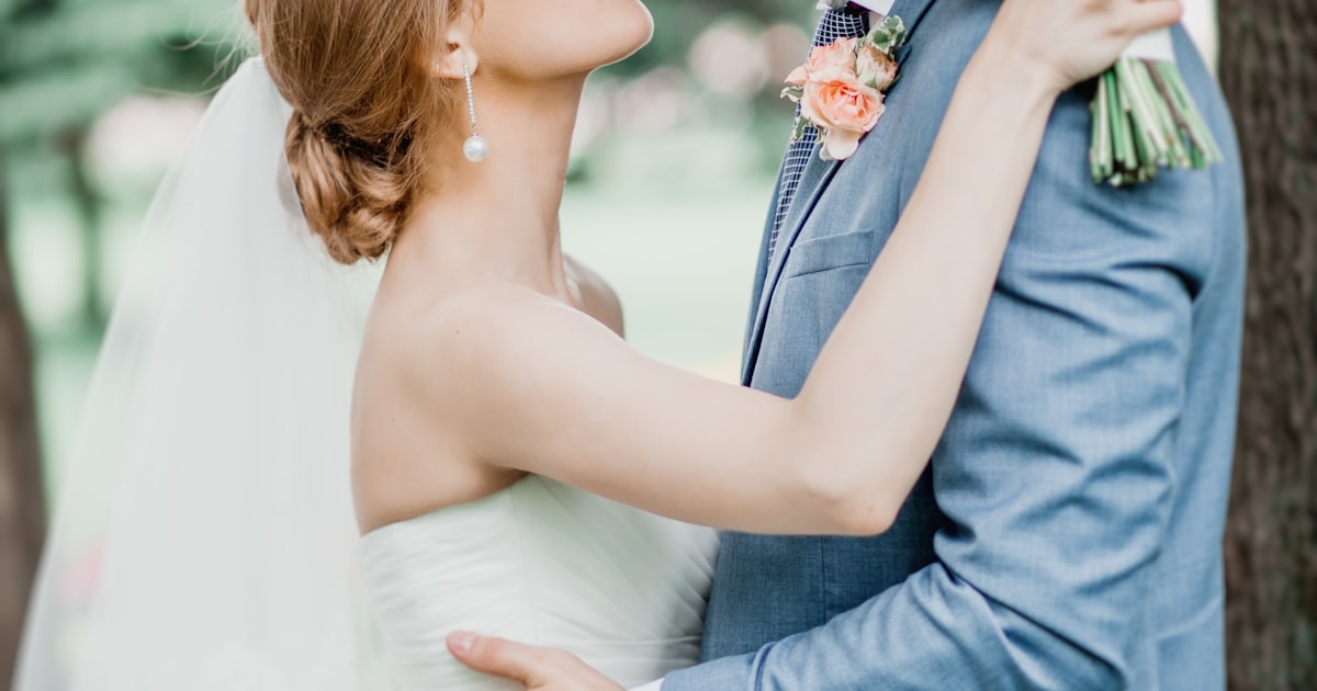 A couple kisses while wedding guests capture the moment with their phones