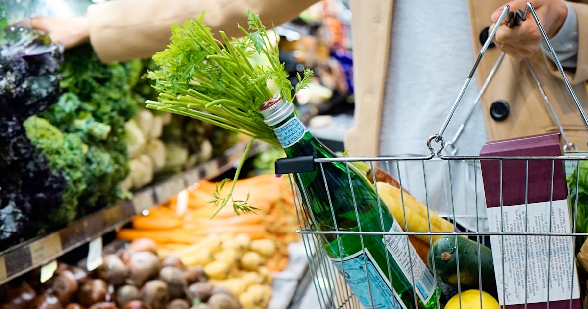Customer with a shopping basket in a supermarket full of products