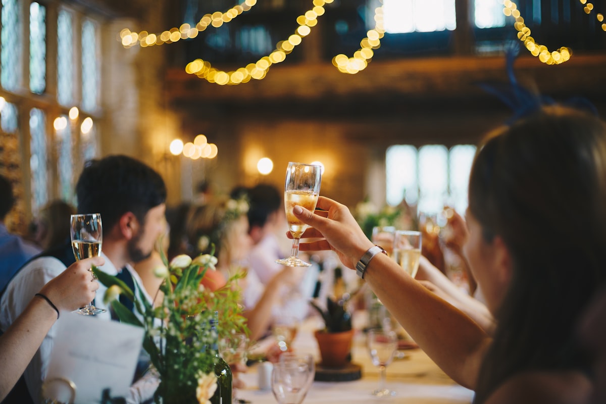Wedding guests raising their glasses for a toast at the reception