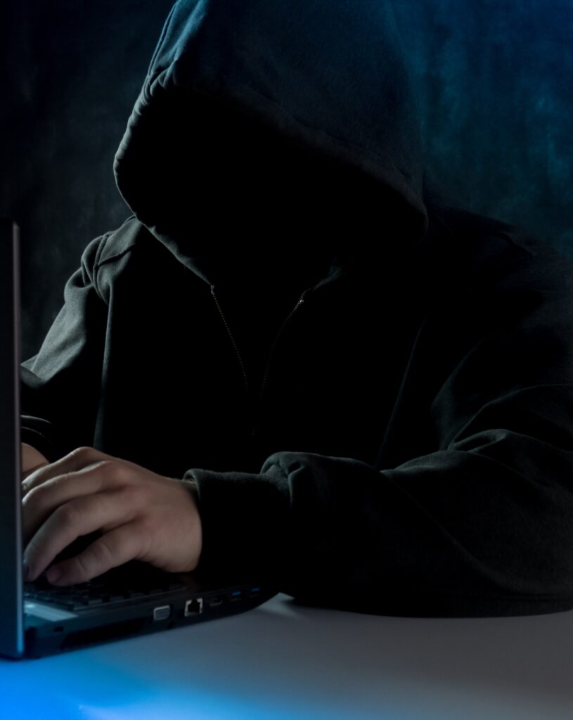 Hacker siting behind laptop