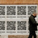 Man passing by some QR code advertisements