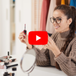 A young woman wearing glasses holds mascara in her hands and is showing it to a camera on the left. The YouTube logo is in the center of the image. With the video QR code, you can easily share any video.