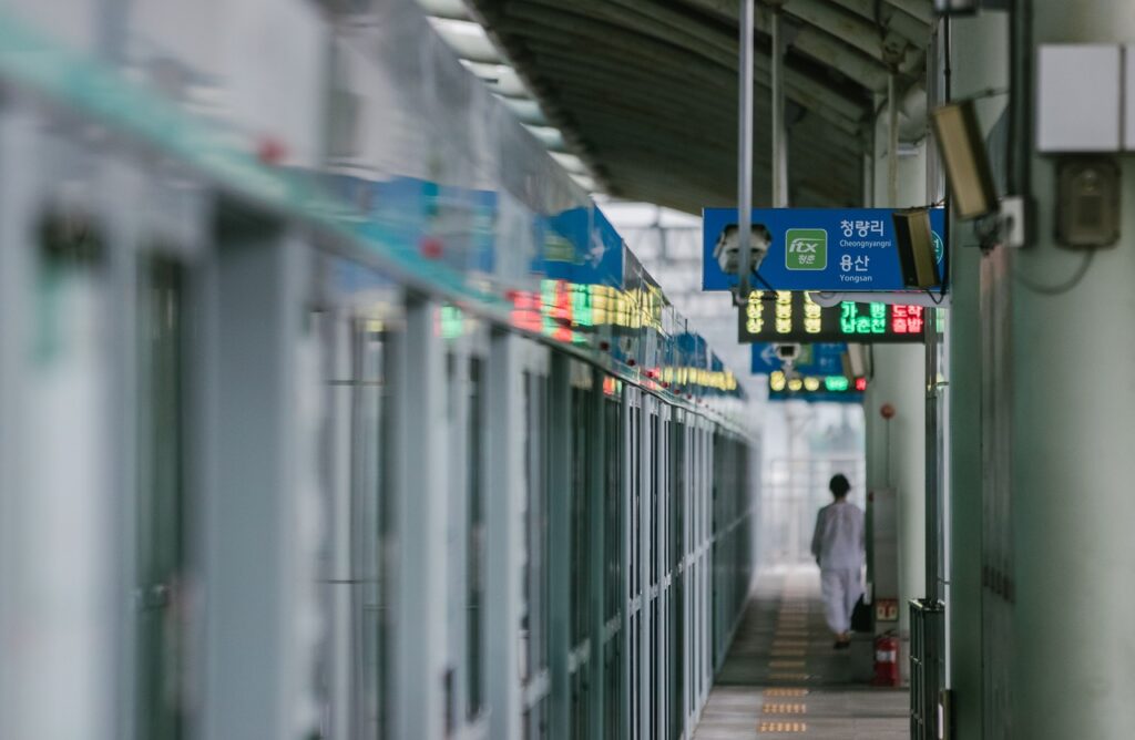 A picture of a subway station which features safety doors on the platform.