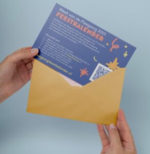 Picture of a person taking a card out of an envelope. A QR code is nicely integrated on the card.