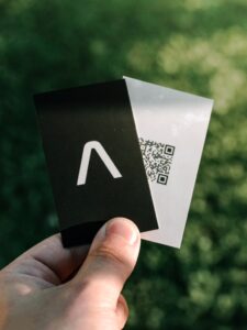 Picture of a person holding a QR code ticket with a cardboard cover half over it.
